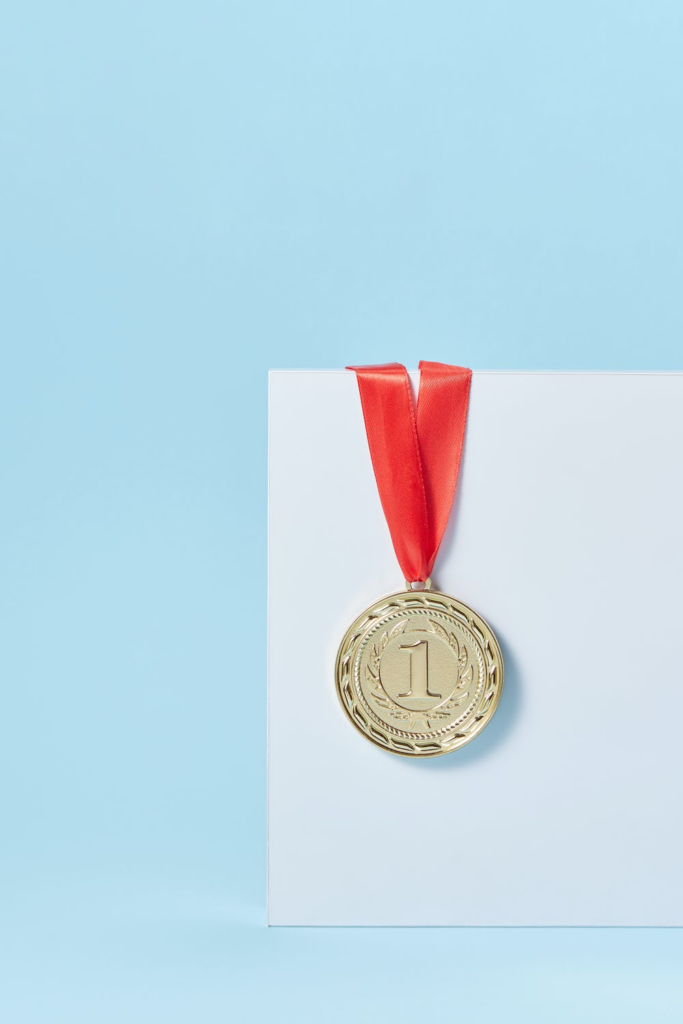 Gouden medaille met rood lint en het nummer '1' erop. Welkom.